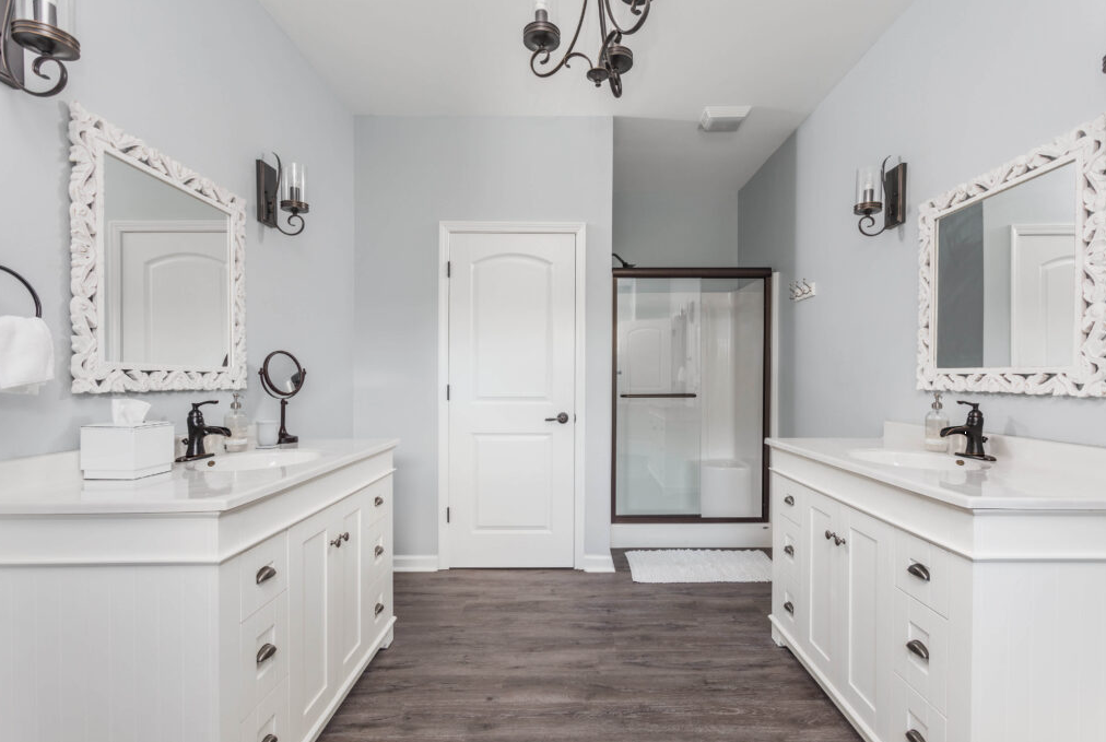 Shared bathroom with double sinks and glass shower