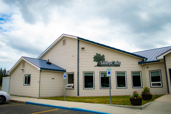 Single-story beige facility with blue roof and accessible parking