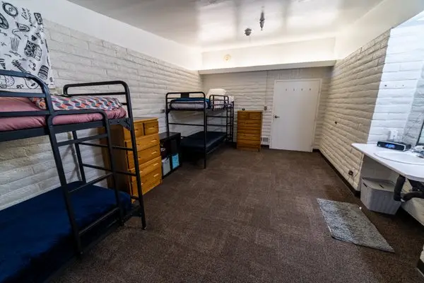 Dorm-style bedroom with bunk beds and dressers