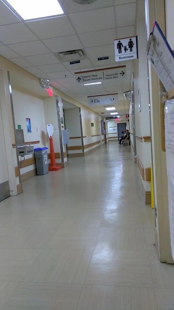 Clinic hallway with signs to restroom and patient services