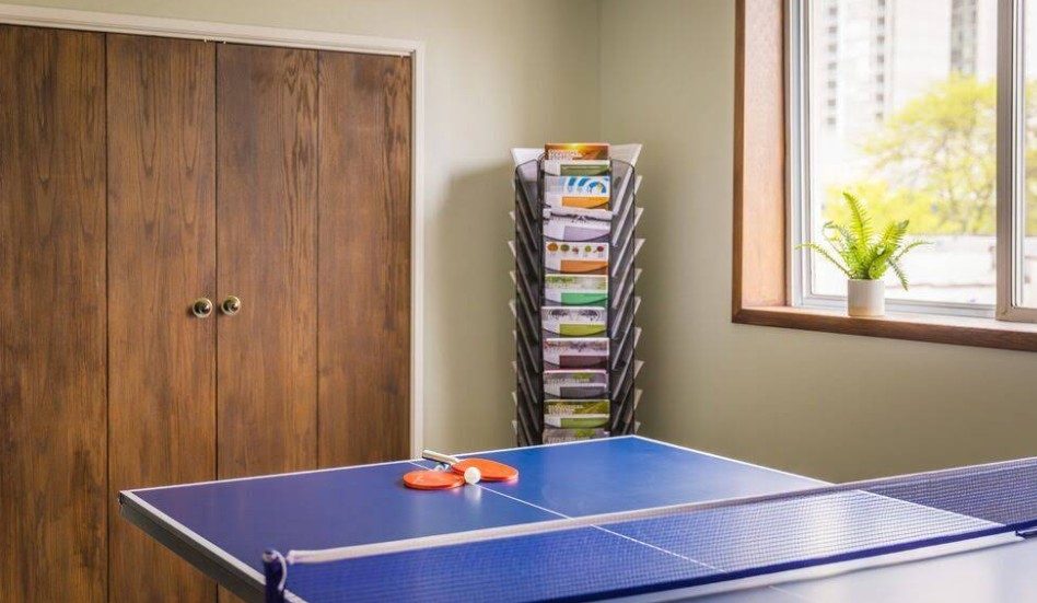 Recreation room with ping pong table and reading materia
