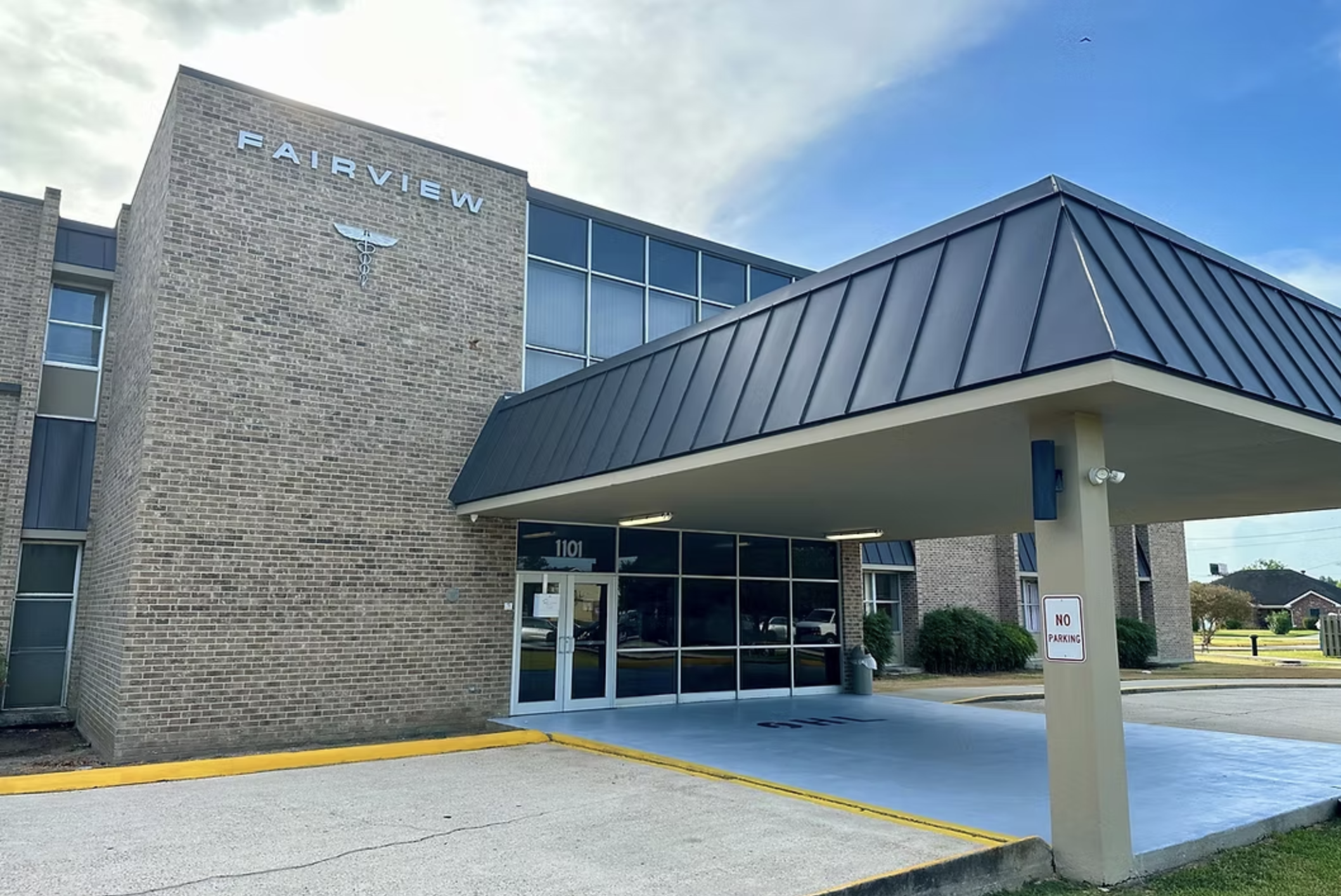 Brick facility building with glass doors and a covered entrance