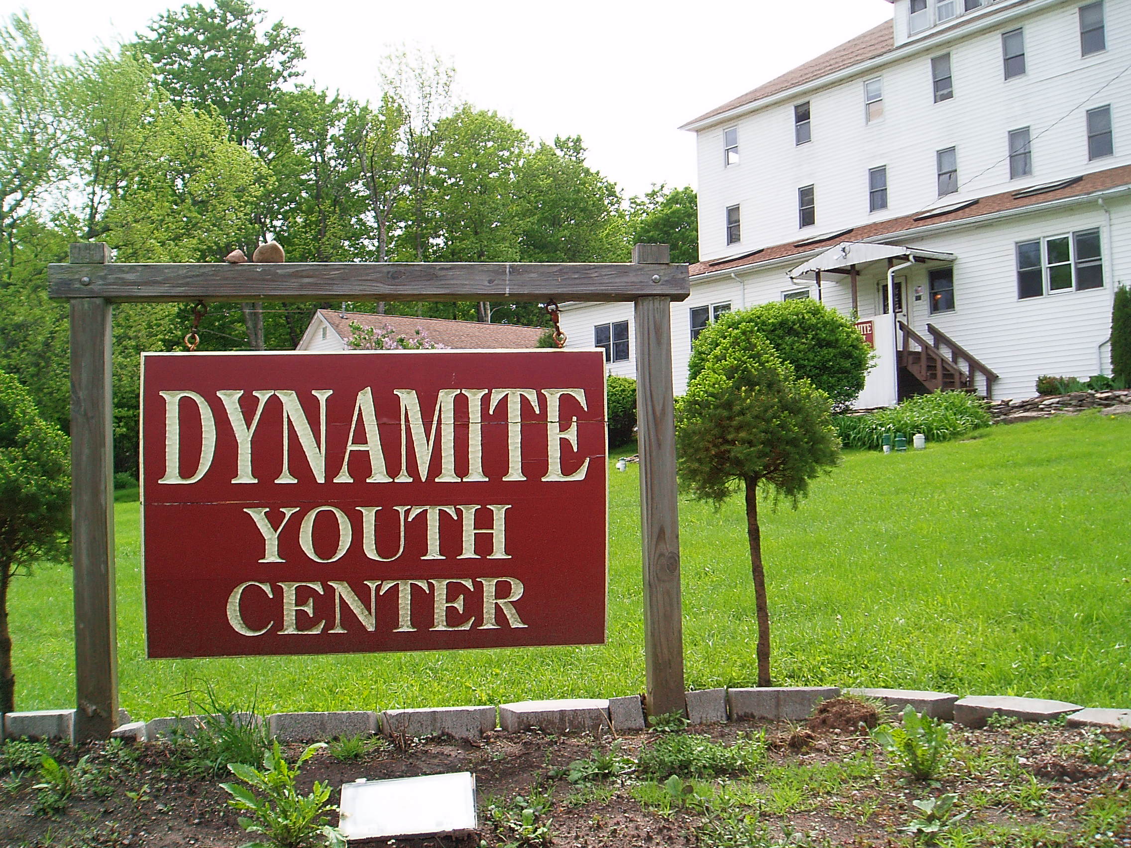 Wooden sign displaying Dynamite Youth Center name