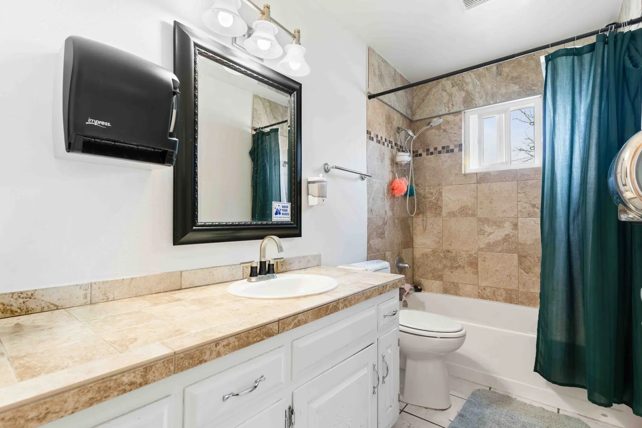 Clean bathroom with vanity, bathtub, and shower curtain
