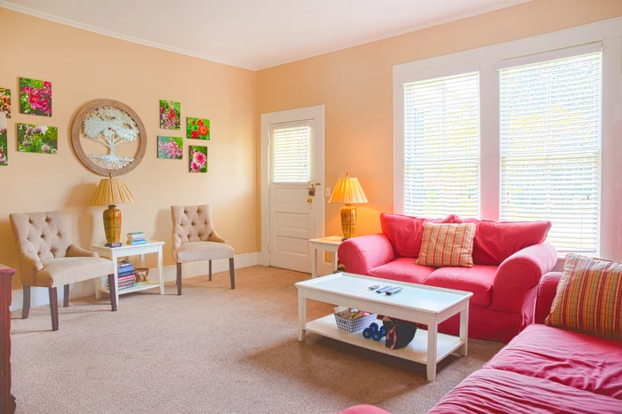 Living room with red sofa, chairs, and bright windows