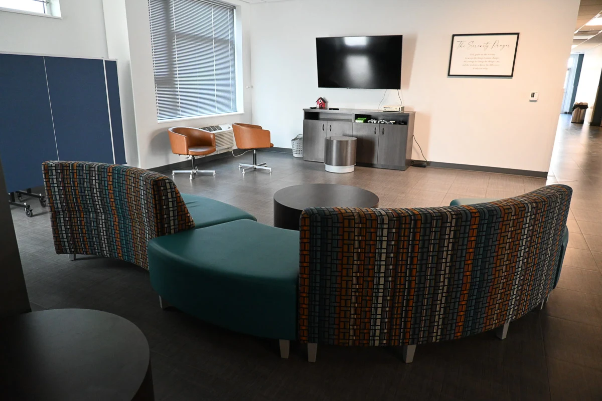 Lounge with patterned chairs, round table, and television