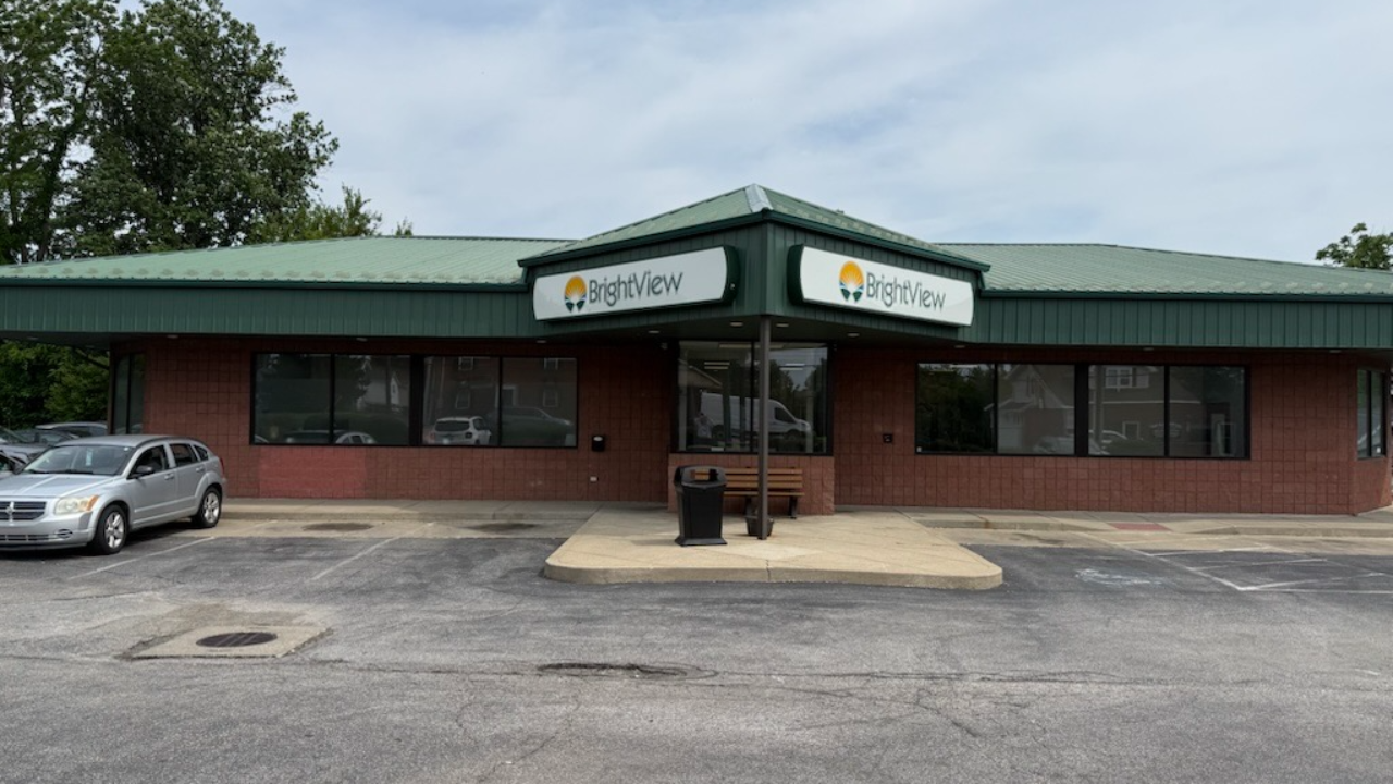 Exterior of BrightView Health Erlanger with red brick walls, green metal roof, BrightView signage, covered entrance, and parking area