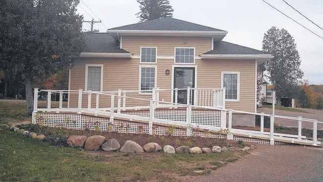 Tan residential facility with ramp and front-facing windows