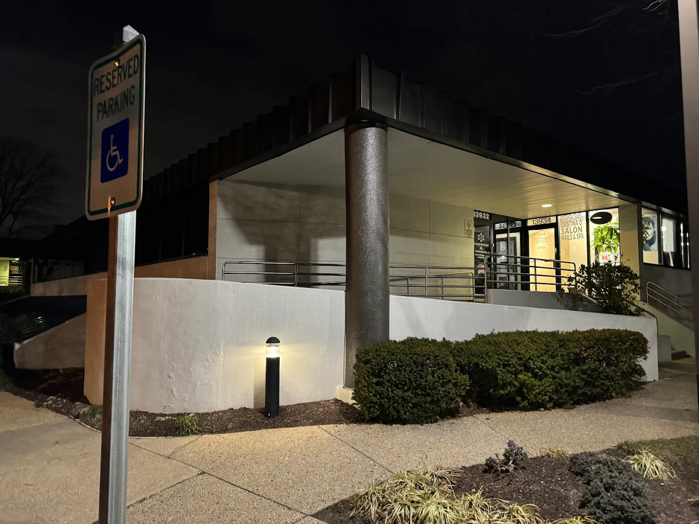 Building exterior at night with reserved parking sign