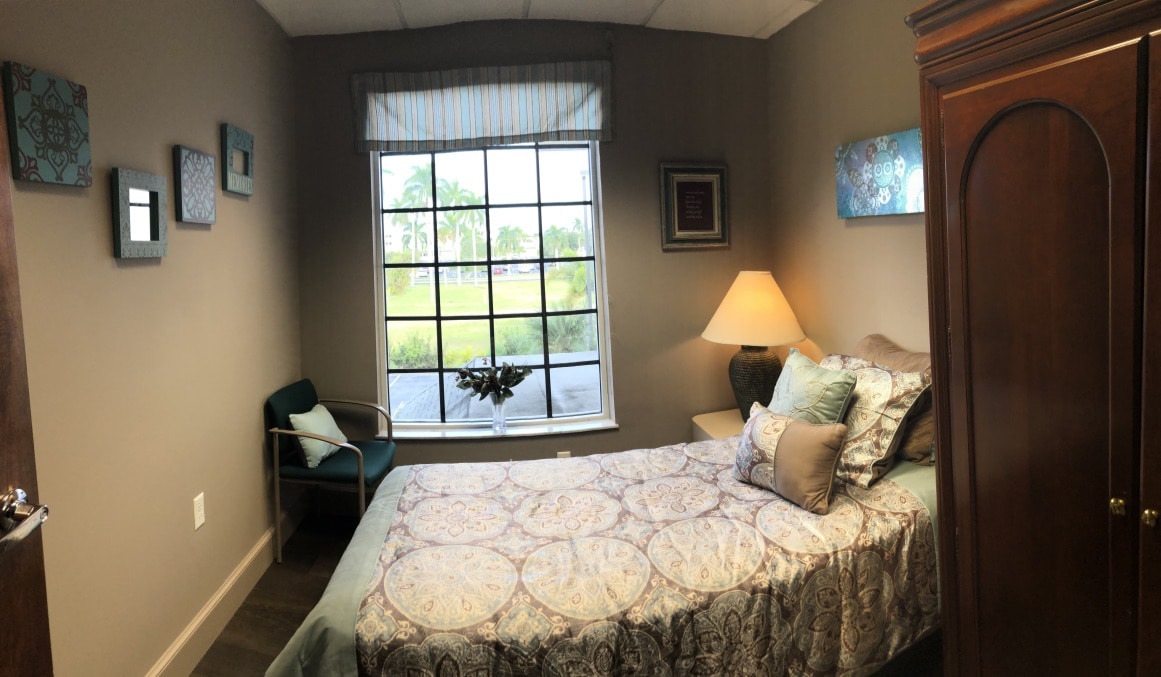 Softly lit bedroom with large window and floral bedding
