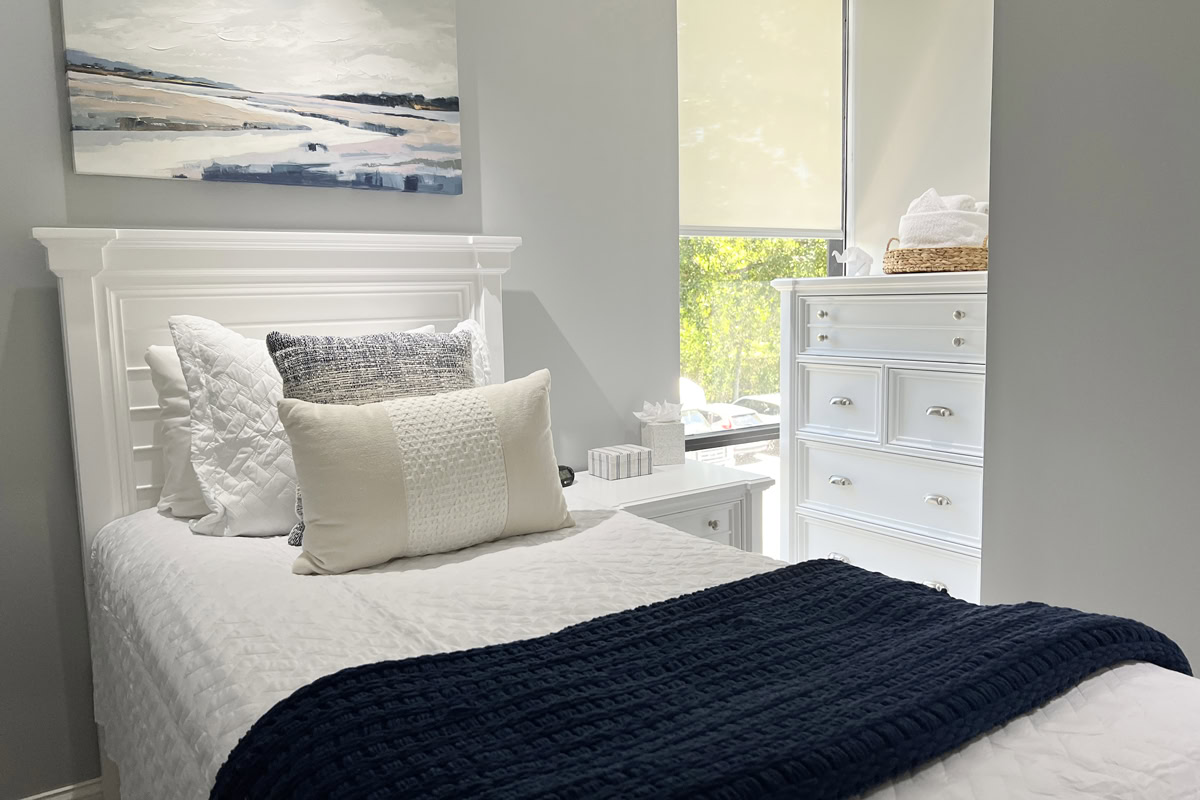 Bright bedroom with single bed and dresser by window