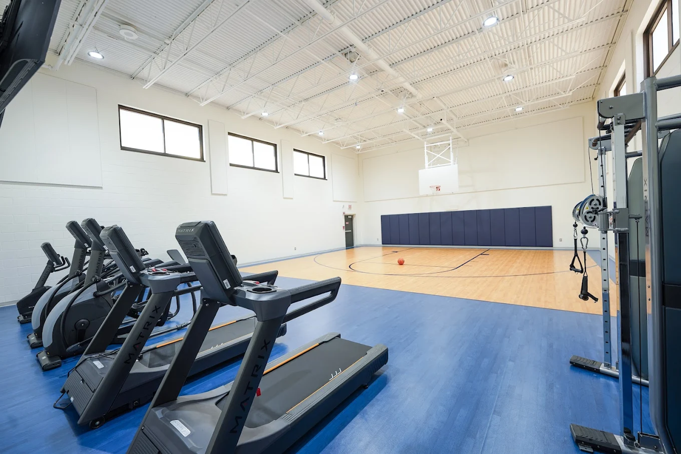 Fitness center with treadmills, weights, and basketball court