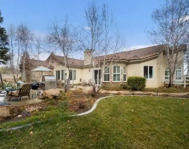 Backyard courtyard with patio seating and landscaped lawn.