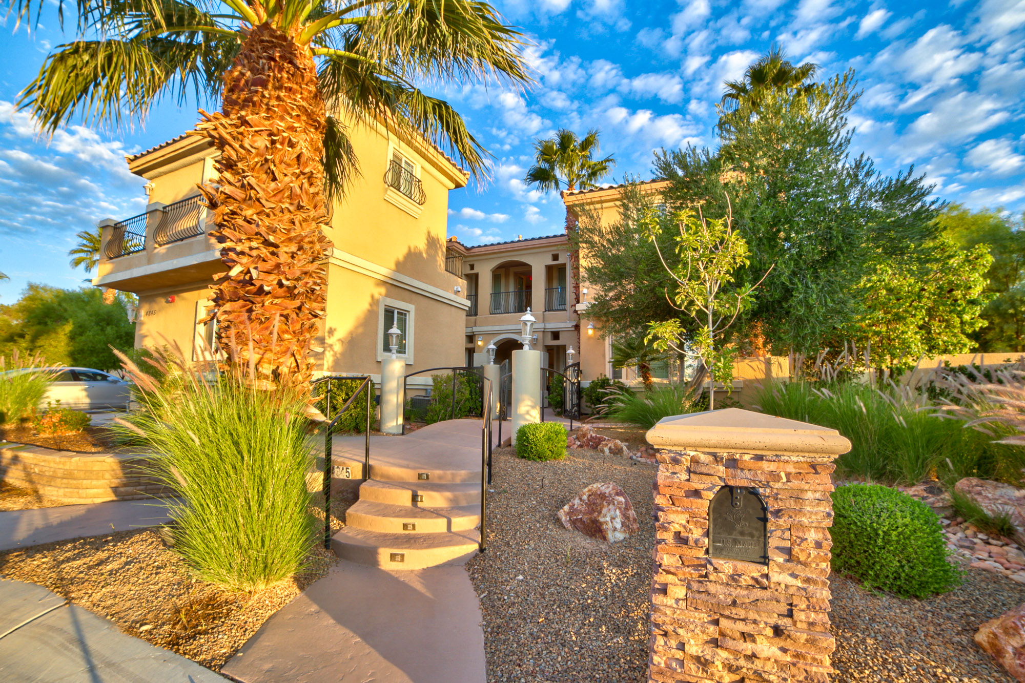 A Mediterranean-style rehab facility with a landscaped entrance.