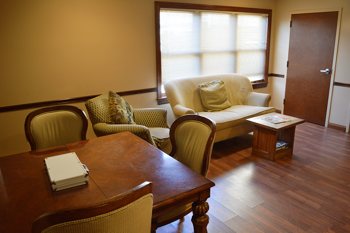 Lounge with sofa, chairs, and wooden table near window