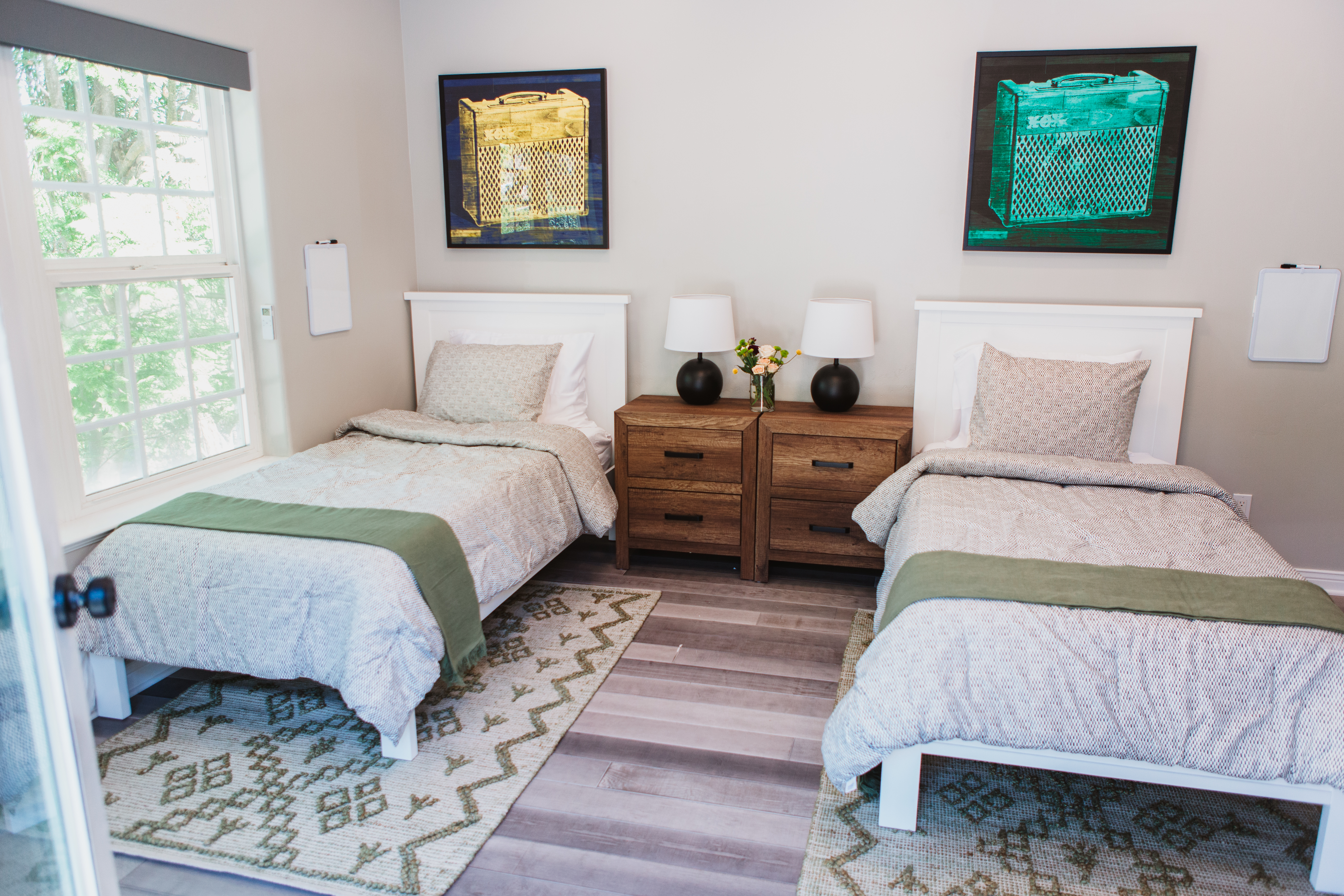 Two beds with wall art and nightstand in between