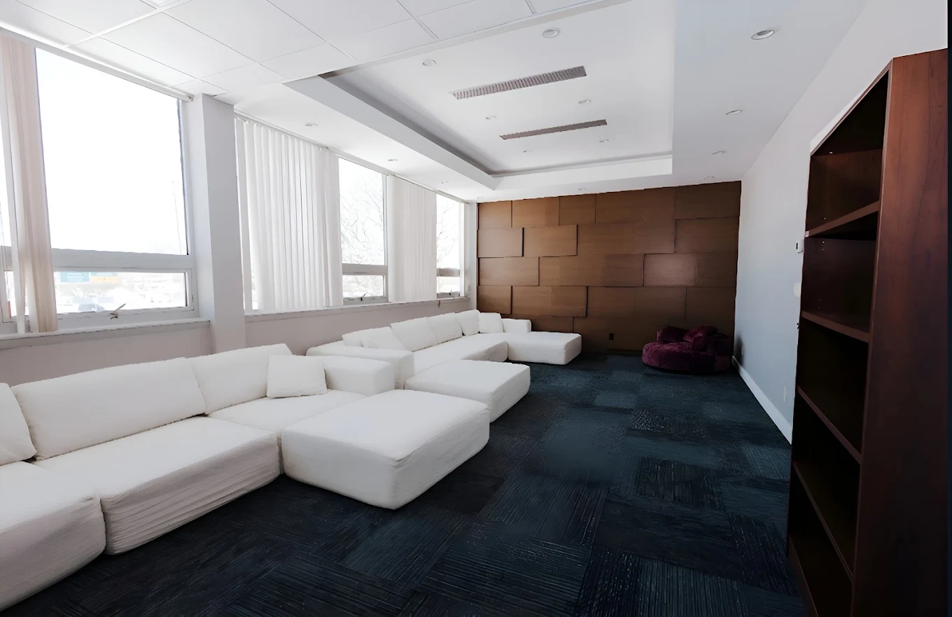 Bright lounge with white sectional sofas and large windows
