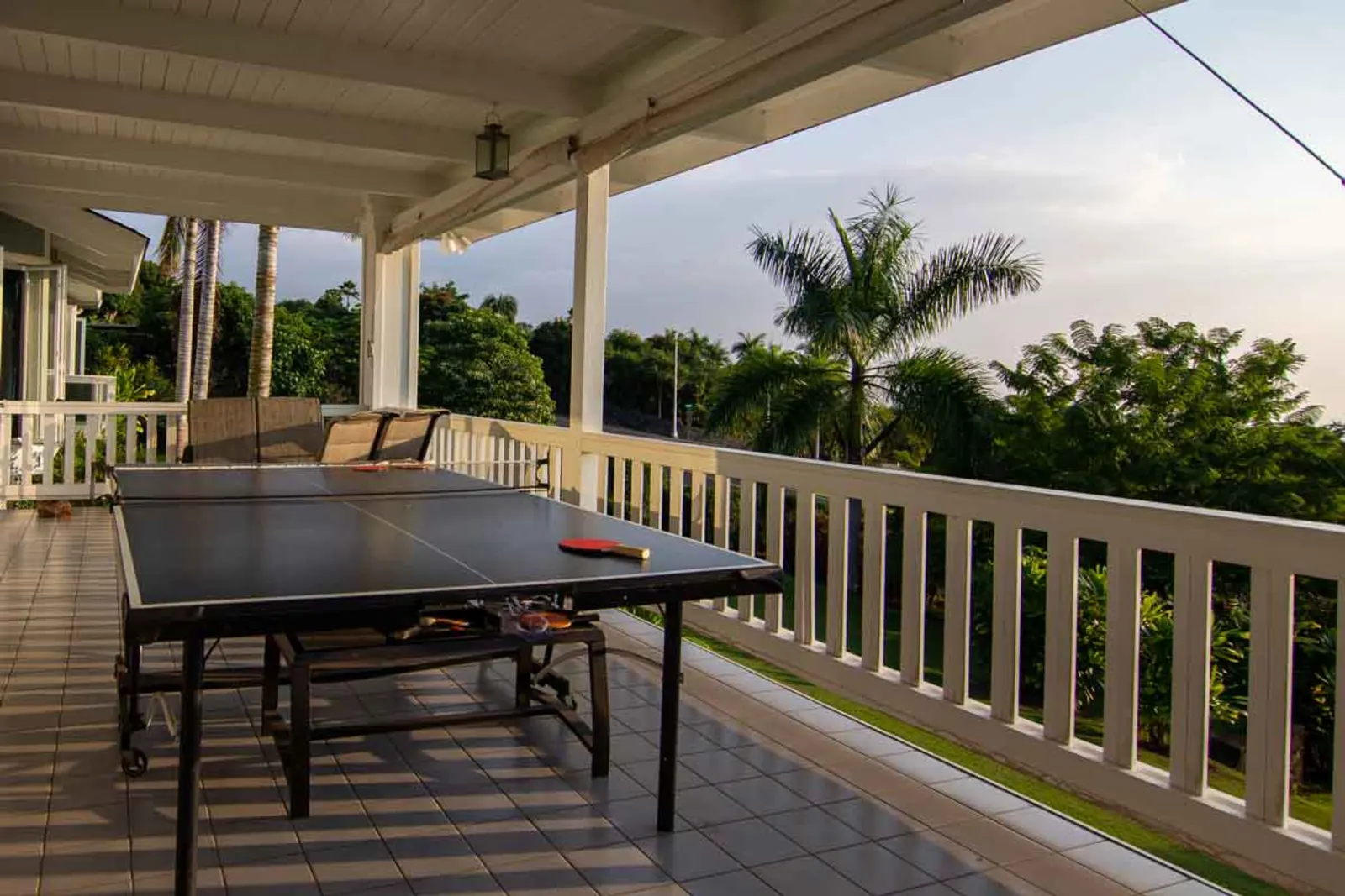 Ping-pong table on covered lanai with palm views
