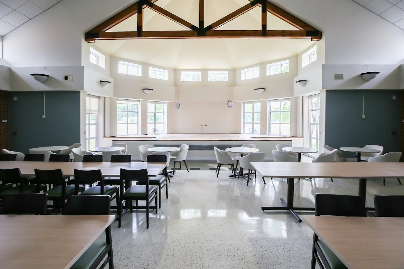 Bright dining room with tables, chairs, and large windows