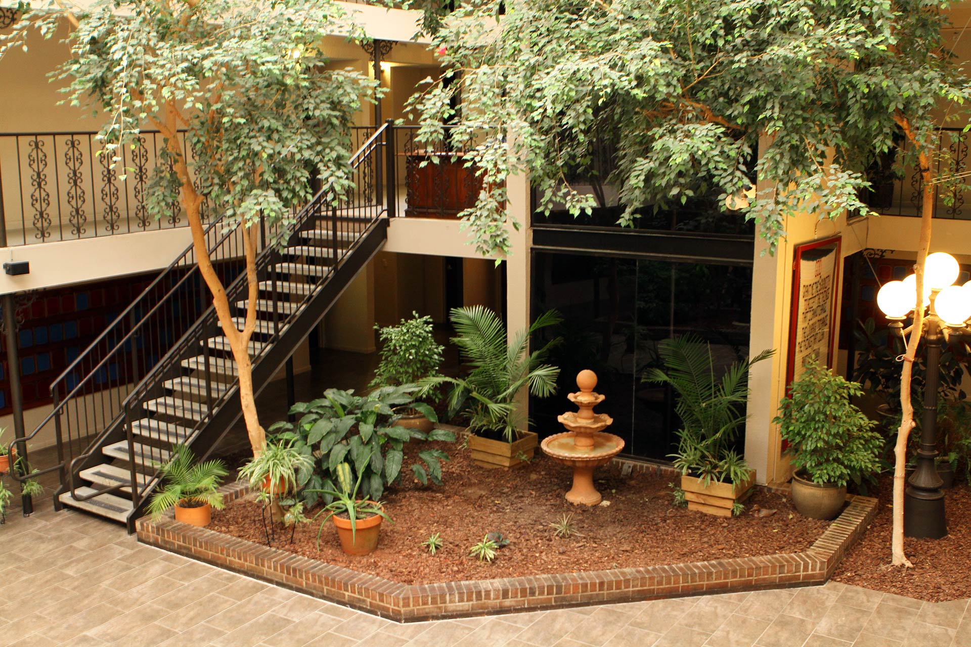 Indoor garden with fountain, plants, and staircase