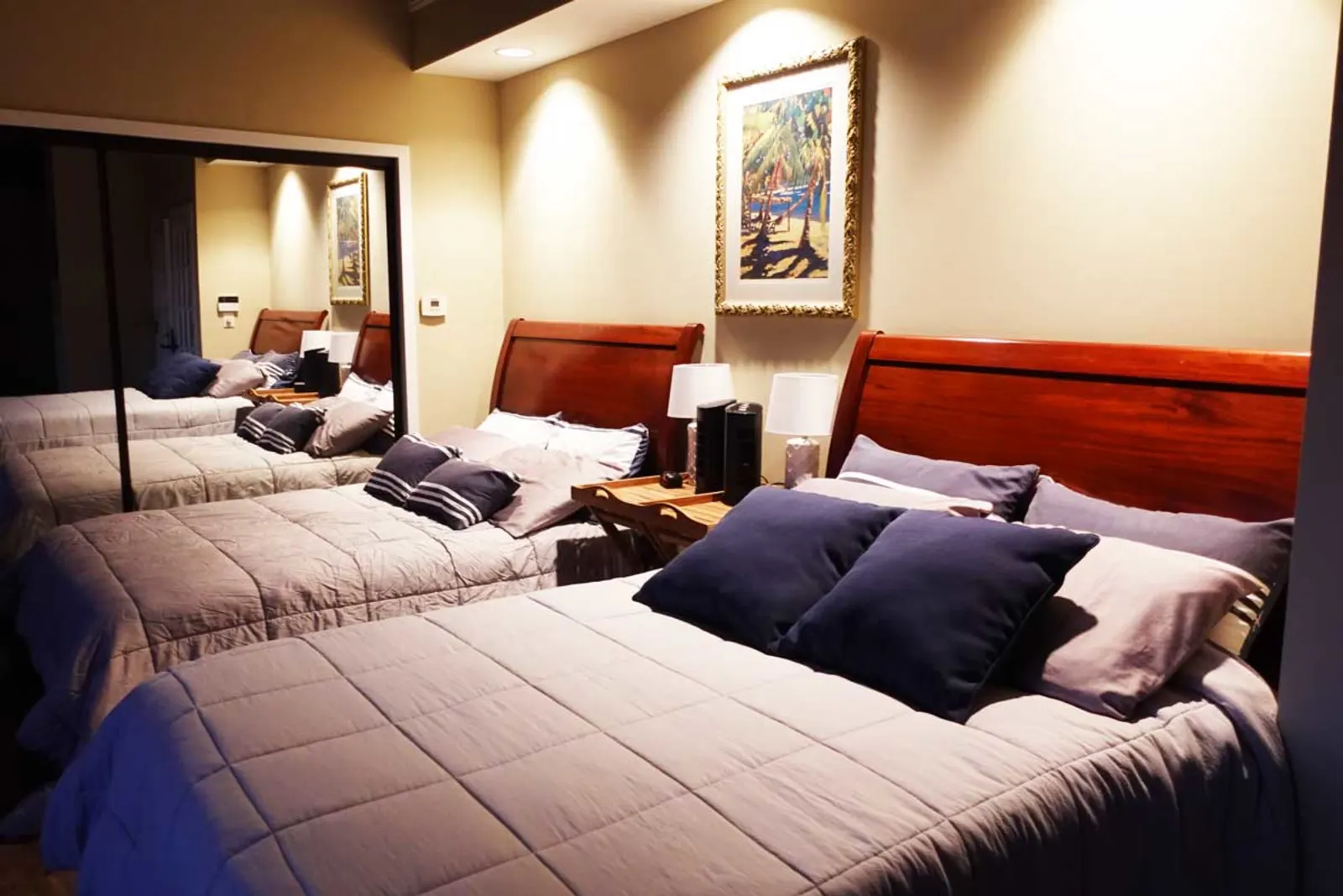 Two beds with lamps and mirrored closet doors