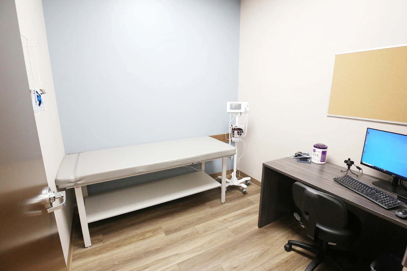 BrightView Elyria clinical room with exam table, vital signs monitor, computer workstation, and medical supplies