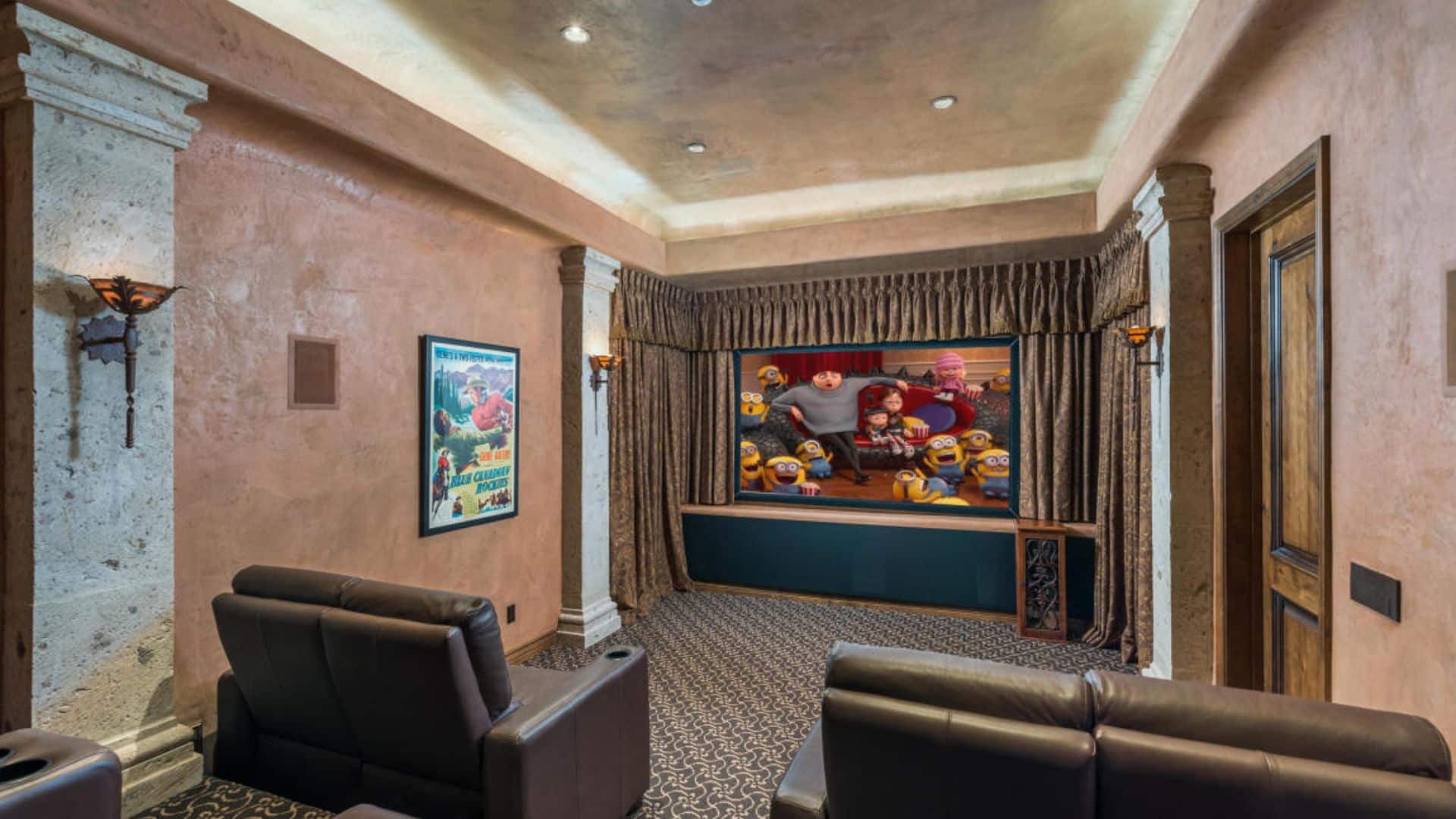 Cinema with a few couches facing a screen.