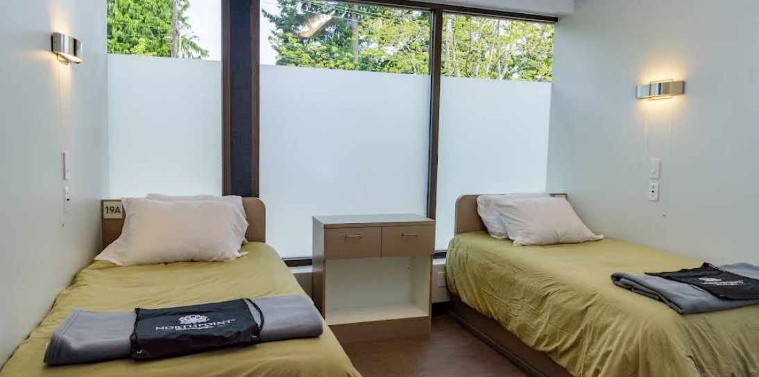 Shared patient room with two beds and large windows