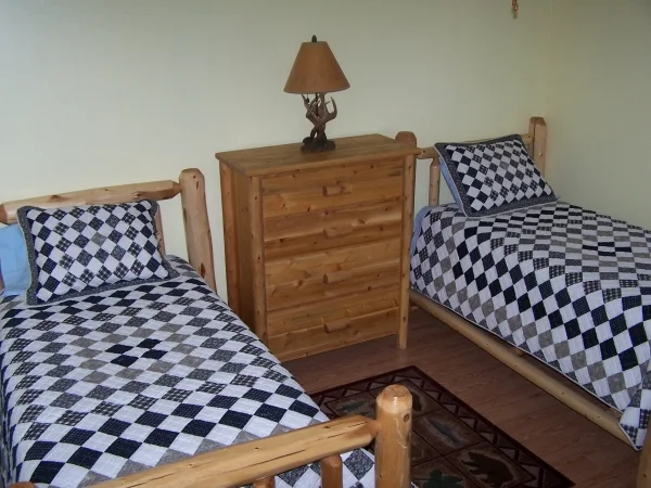 Shared bedroom with two wooden twin beds and matching patterned bedding