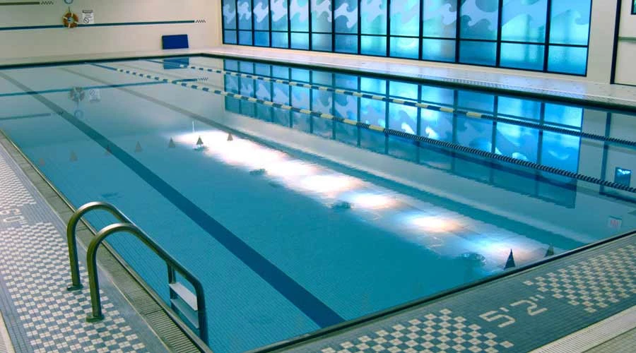Empty lap pool with tiled floor and wave design windows