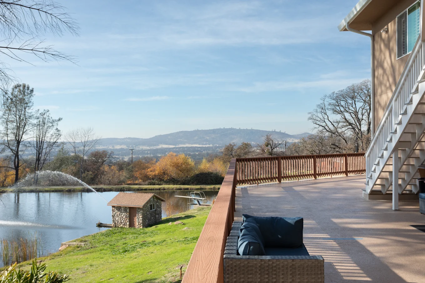Fountain spraying in pond with deck and valley view