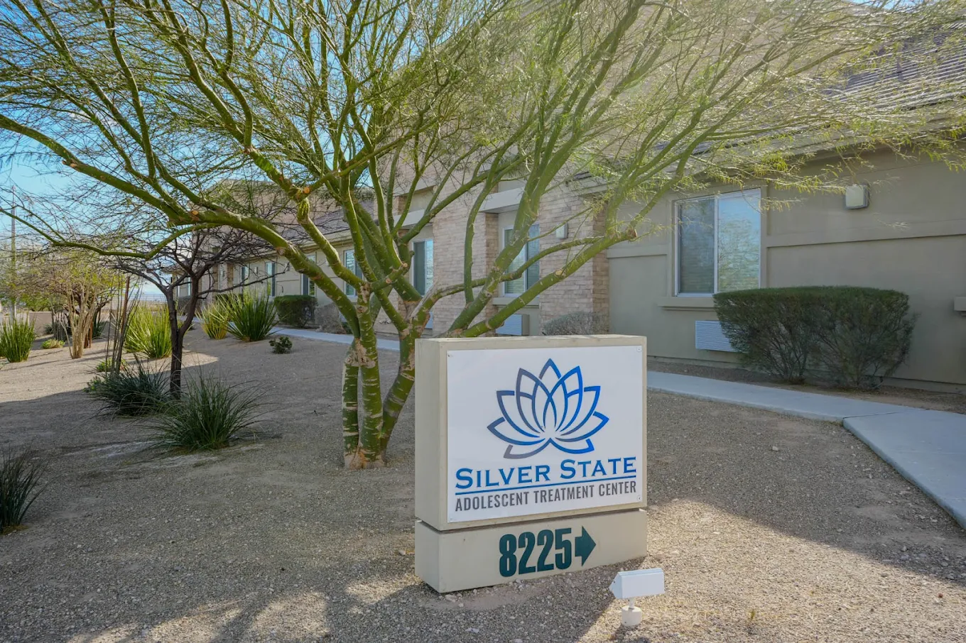 Silver State facility sign with trees and building