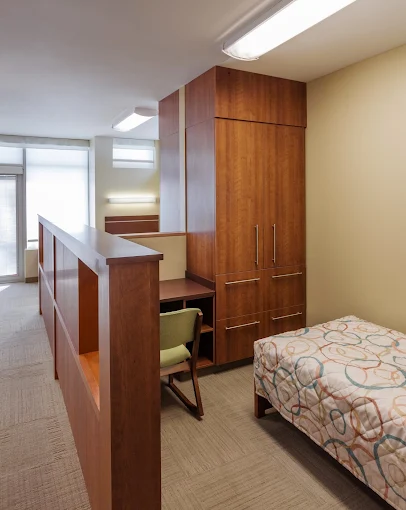 Cozy room with bed, built-in wood storage, and desk area