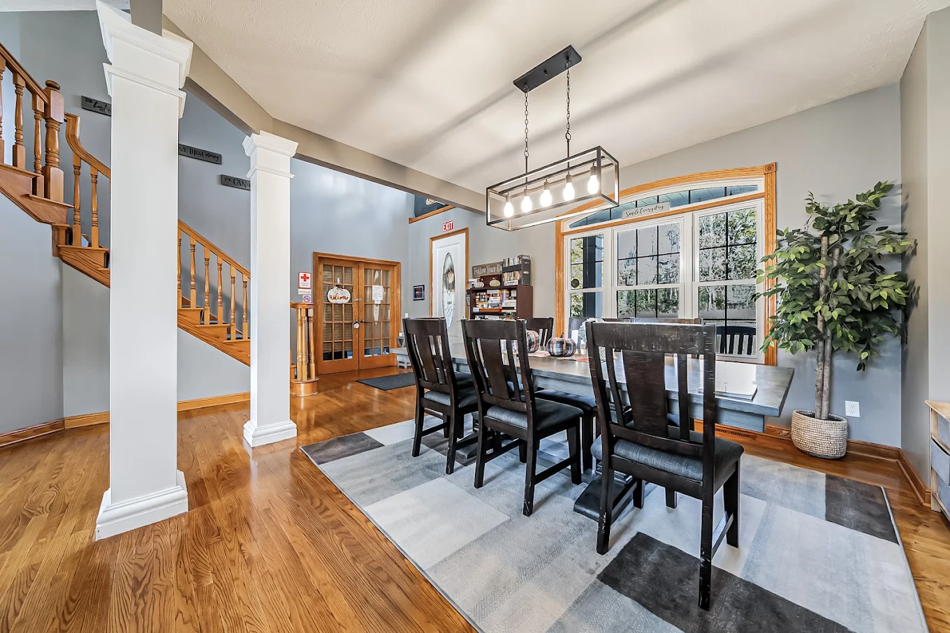 Dining room with large table, chairs, and hardwood flooring