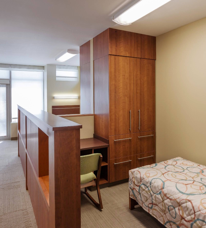 Private bedroom with bed, desk, wardrobe, and natural light