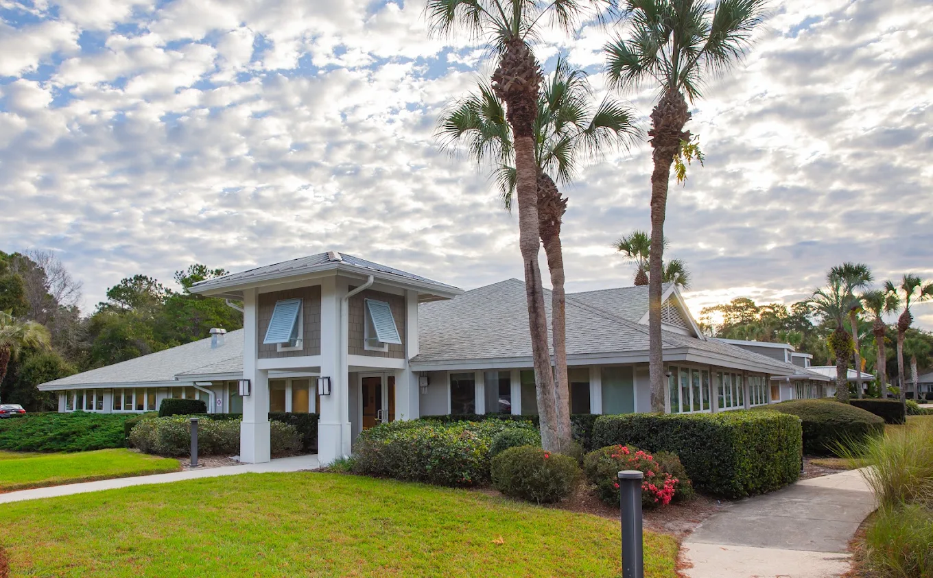 Main facility building surrounded by palm trees and landscaping