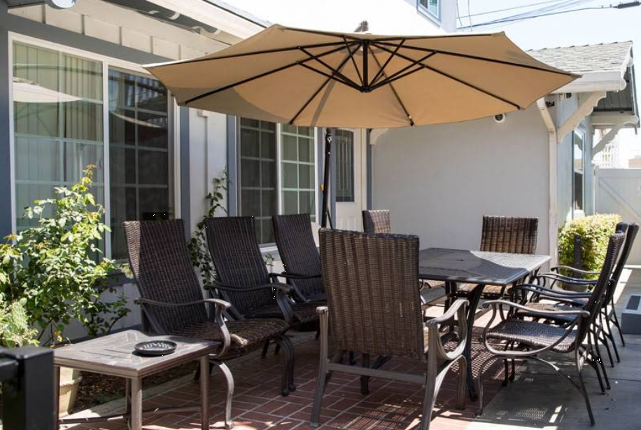 Patio dining set with umbrella and wicker chairs