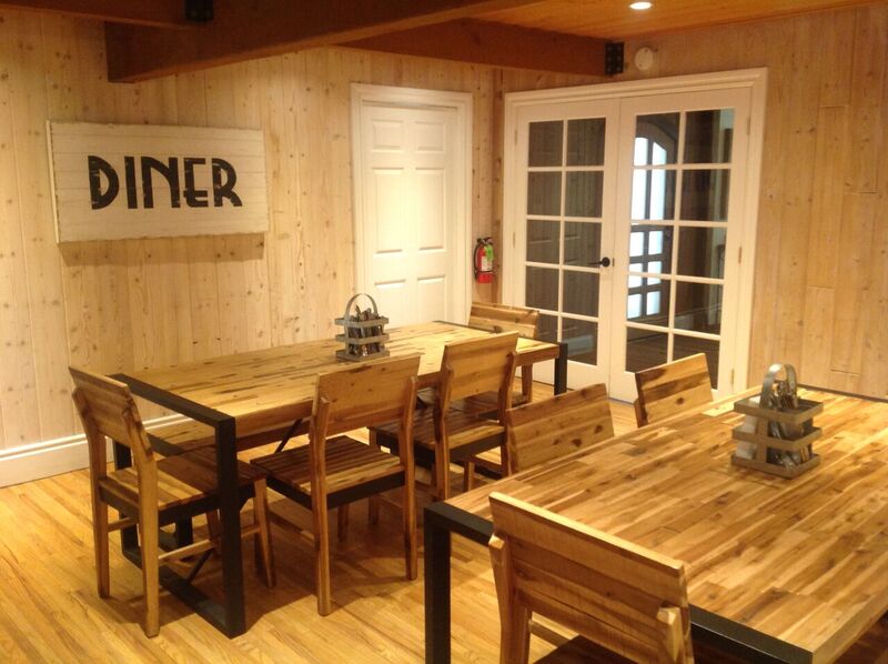 Wood dining tables and chairs in a warm, cabin-style dining room