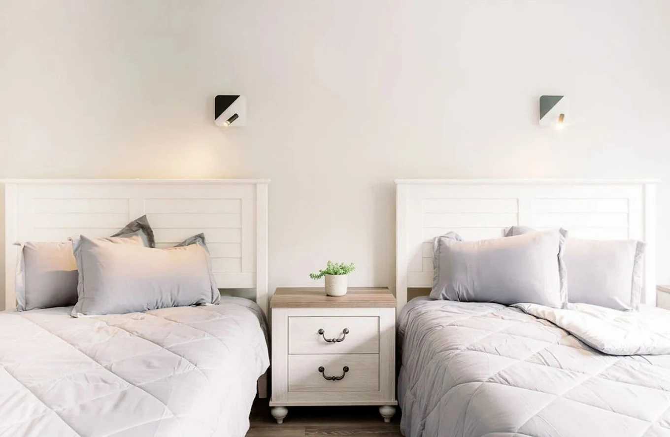 Shared bedroom with two beds and nightstand