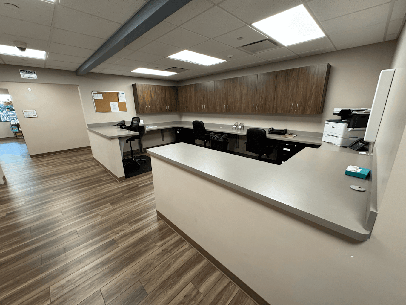 Reception station with counters, cabinets, and office chairs