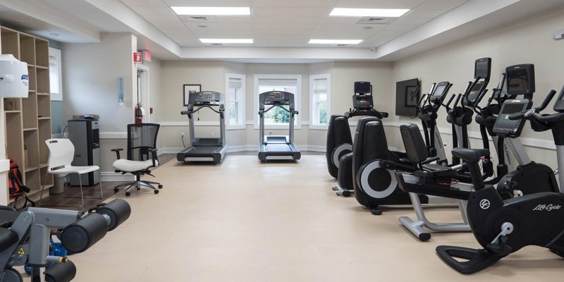 A well-equipped fitness room with modern exercise machines, bright lighting, and a clean, organized layout, ideal for maintaining a healthy lifestyle.