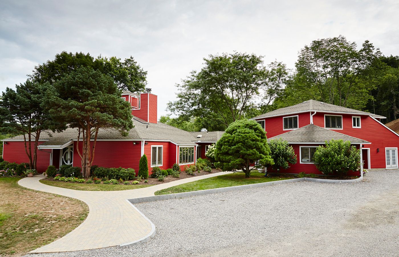 Red residential-style treatment facility surrounded by trees.
