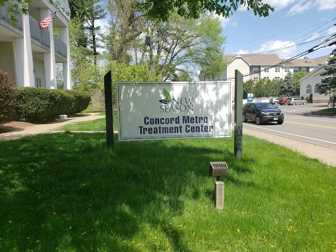 Lawn sign with clinic name near road and parking lot