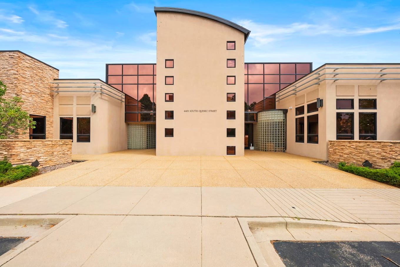 Modern building entrance with glass panels and a beige facade.