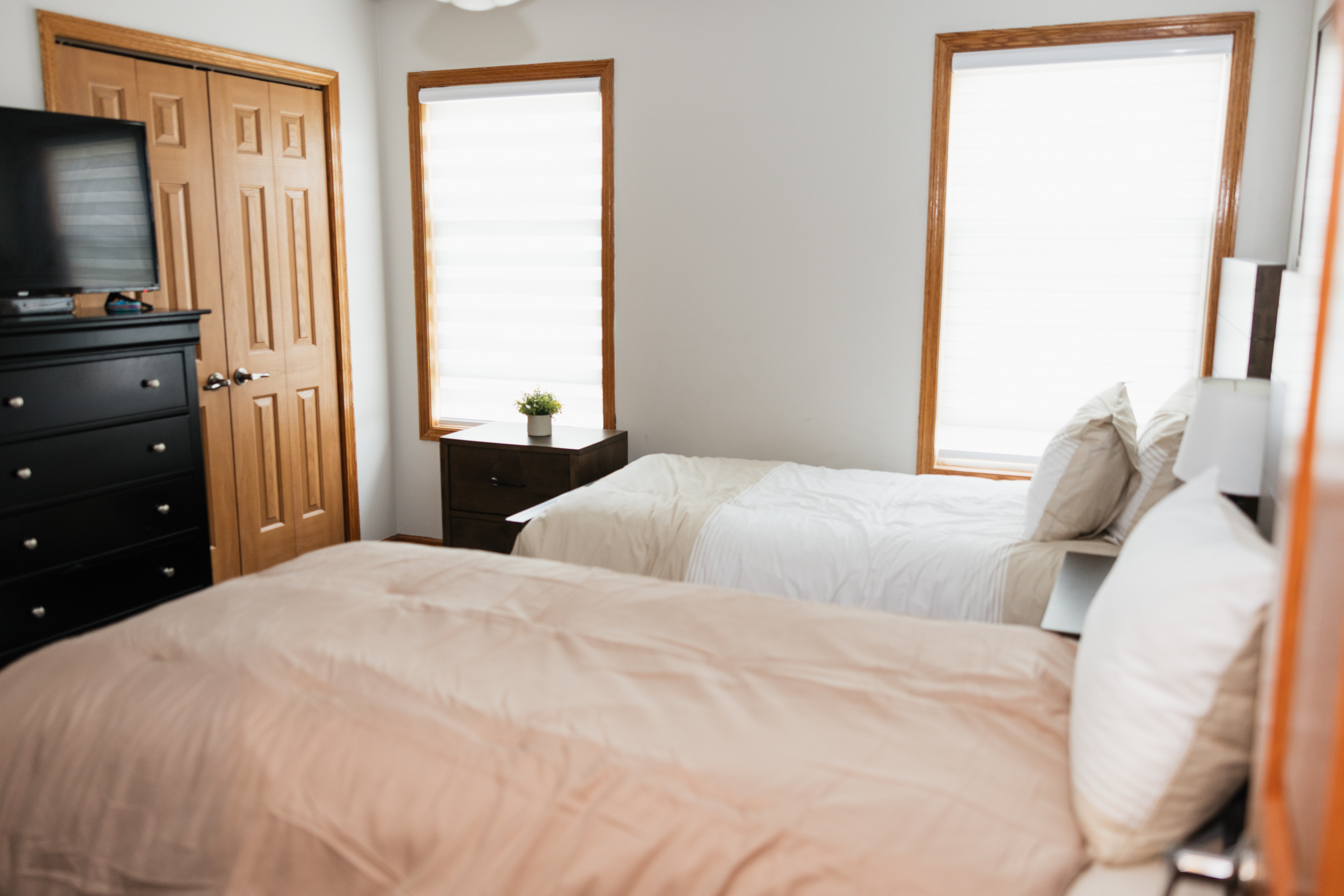 Two cozy beds in bright, neutral-colored room