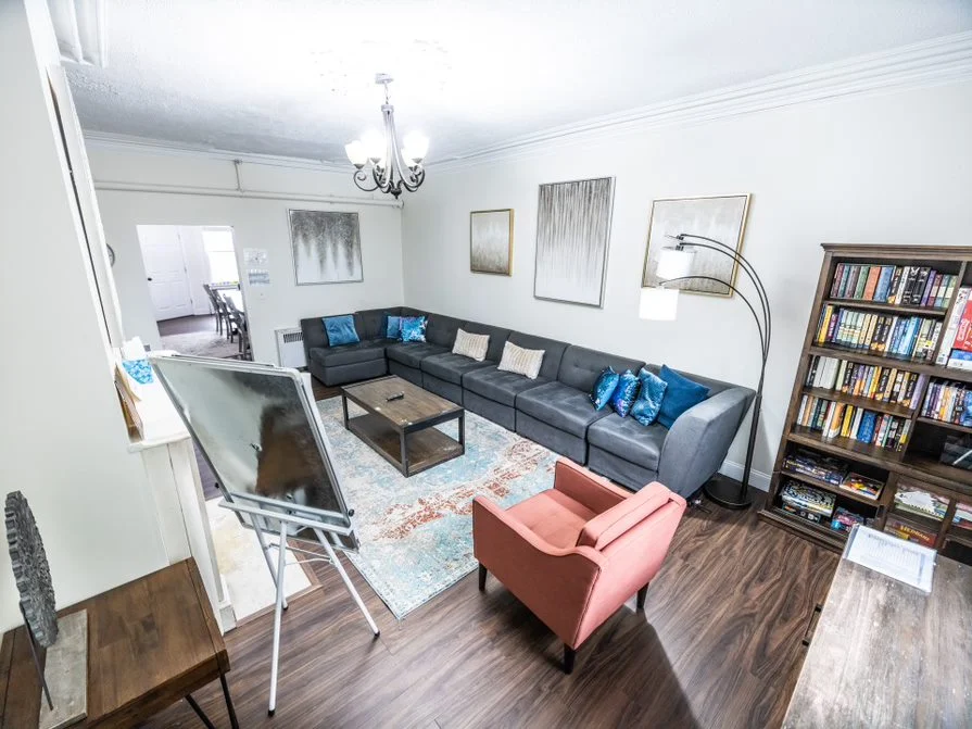 Community living room with sectional sofa and bookshelf