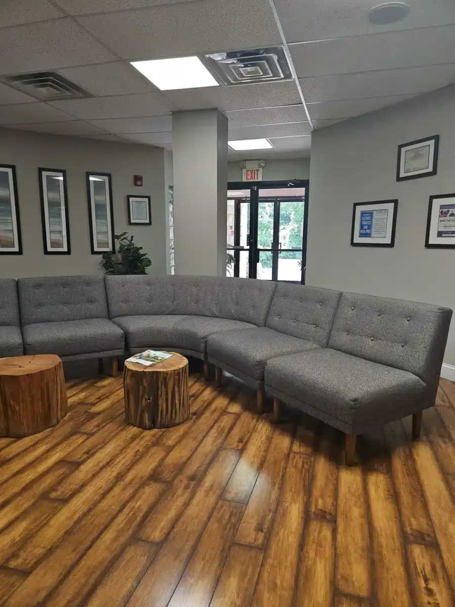 Comfortable waiting area with sectional seating and wood floors