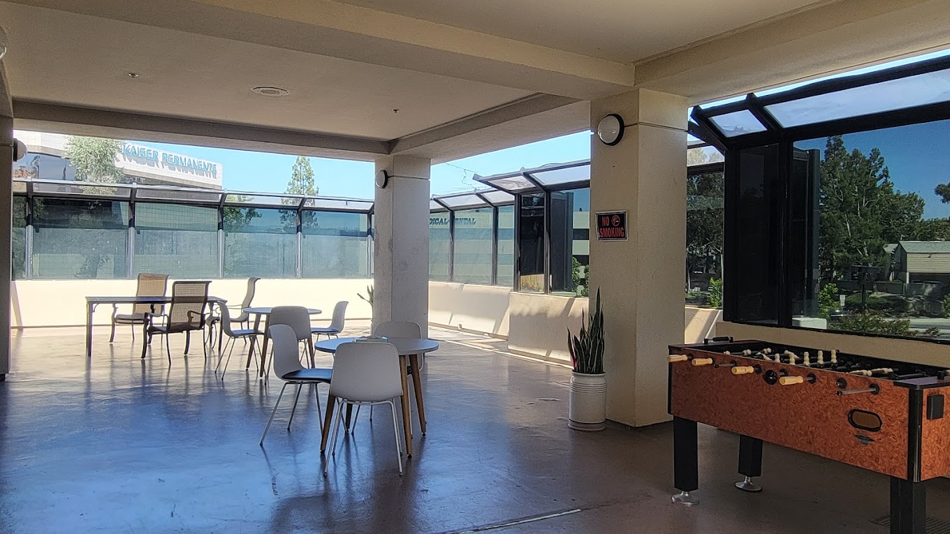 An open-air patio with tables, chairs, and a foosball table