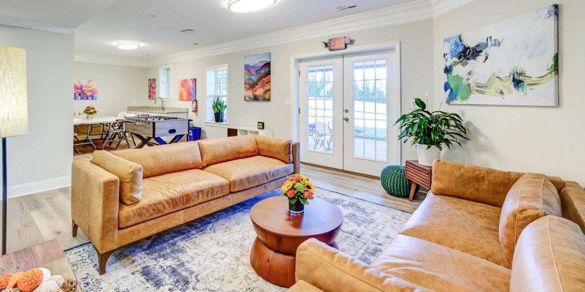 Lounge with leather sofas, football table, and colorful artwork