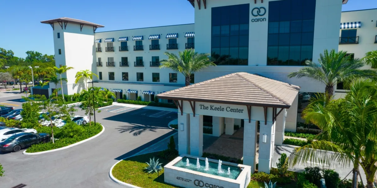 Modern white building with palms and entry fountain